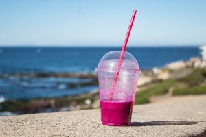 transparent plastic cup with pink liquid, with plastic lid and plastic straw